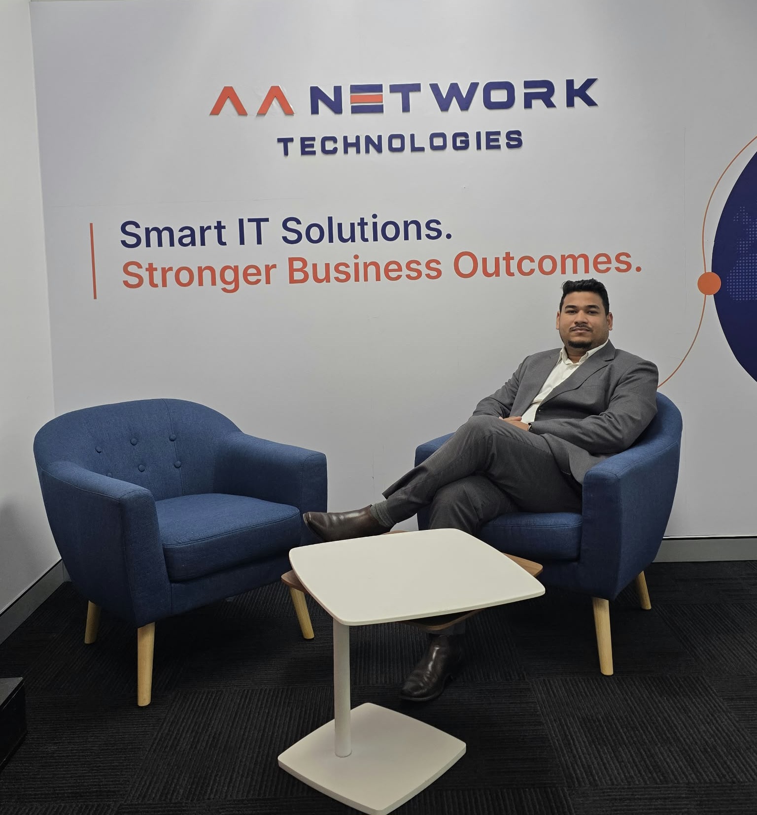 Ronit Raj Sriwastav, Founder of AA Network Technologies, seated in the Sydney office reception under the Smart IT Solutions, Stronger Business Outcomes banner